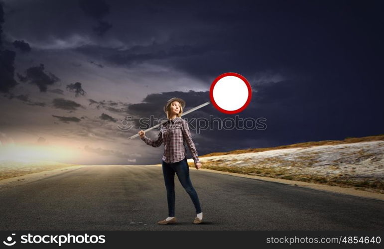 Young girl in casual holding stop sign