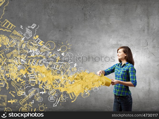 Young girl in casual splashing colorful paint from bucket