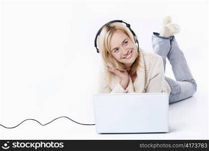 Young girl in headphones with a laptop on a white background