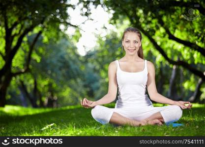 Young girl in lotus pose in the park