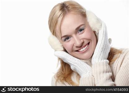 Young girl in mittens and headphones on a white background