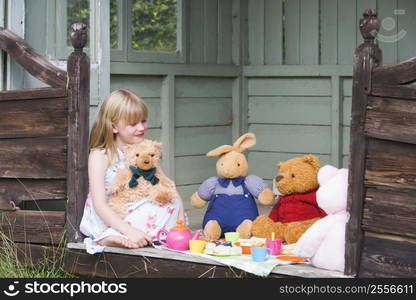 Young girl in shed playing tea and smiling