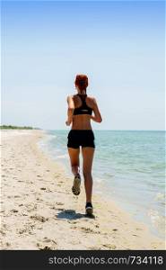 young girl in sportswear jogging on a deserted sea coast. girl running seaside