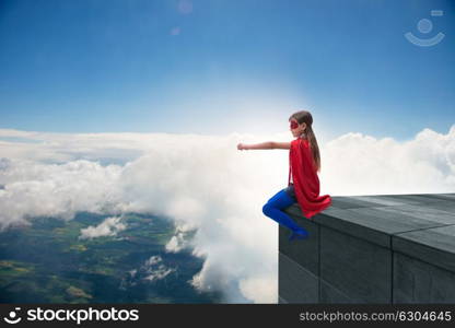 Young girl in superhero costume overlooking the city