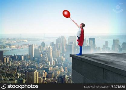 Young girl in superhero costume overlooking the city
