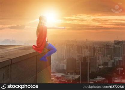 Young girl in superhero costume overlooking the city