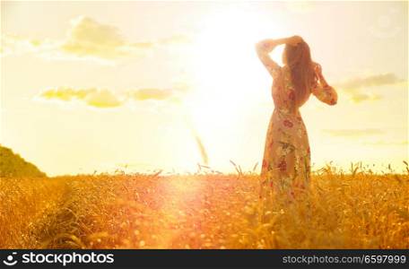 Young girl in wheat field at sunset