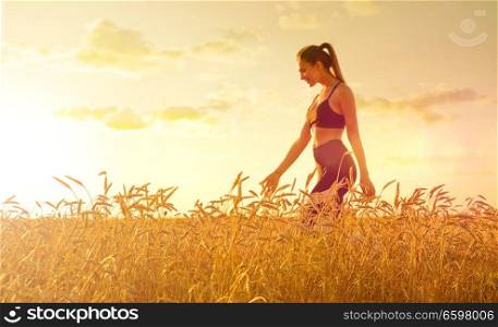 Young girl in wheat field at sunset