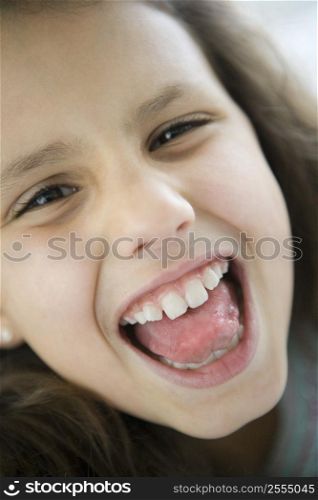 Young girl indoors shouting and smiling (high key)