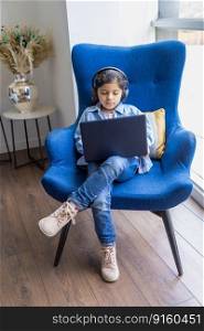 Young girl is using her laptop on the living room sofa
