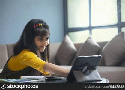 Young girl joining her online class on tablet while sitting at home during lockdown