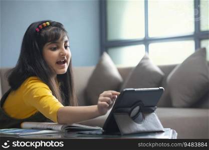 Young girl joining her online class on tablet while sitting at home during lockdown