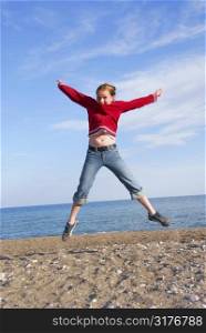 Young girl jumping on a beach