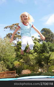 Young Girl Jumping On Trampoline In Garden