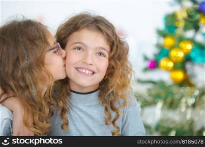 Young girl kissing cheek of friend