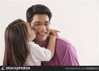 Young girl kissing her father