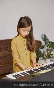 young girl learning how play electronic keyboard