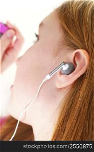 Young girl listening to music on her mp3 player, closeup
