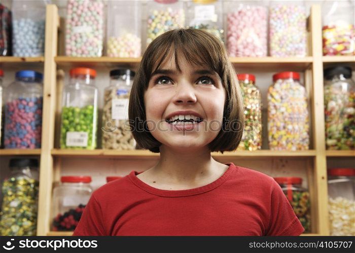 young girl looking in awe at rows of sweets
