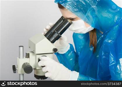 young girl looking through a microscope