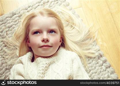 Young girl lying on rug