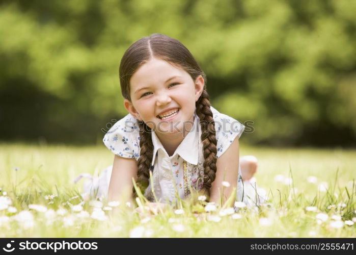 Young girl lying outdoors smiling