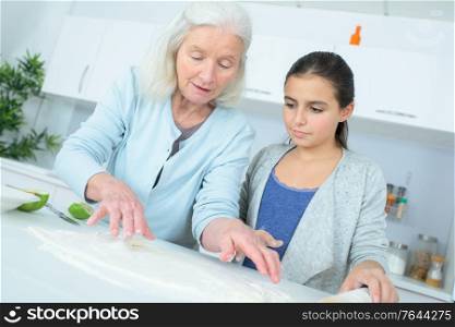 young girl making a cake with her nanny