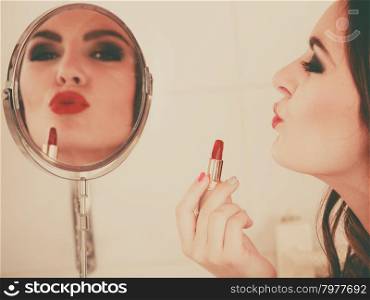 Young girl making makeup. Young girl making makeup in bathroom. Woman take care about look. Looking into a mirror. Giving kiss