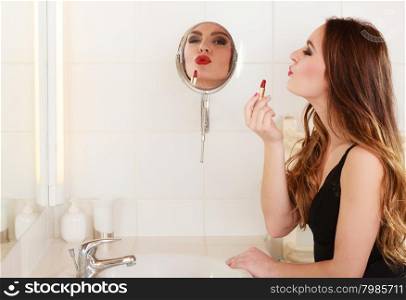 Young girl making makeup. Young girl making makeup in bathroom. Woman take care about look. Looking into a mirror. Giving kiss