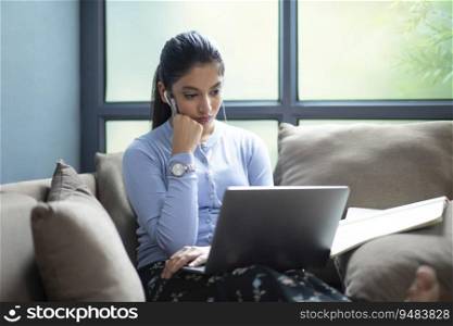 YOUNG GIRL MAKING NOTES WHILE ATTENDING ONLINE CLASS