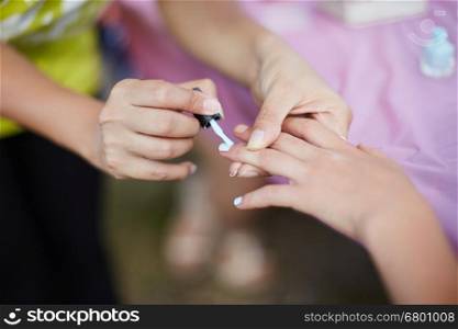 young girl on a manicure. paint nails with nail polish