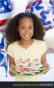 Young girl on fourth of July with balloons and cookies smiling