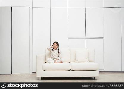 Young Girl on Sofa Using Cell Phone