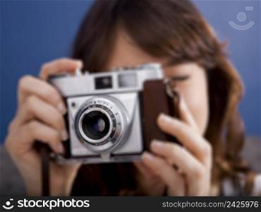 Young girl on the bed holding a photographic camara and shooting