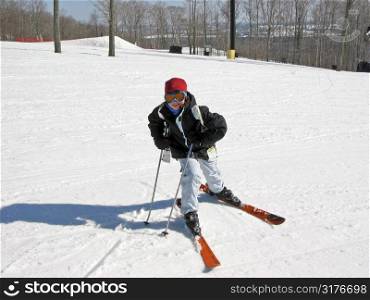 Young girl on the slope of a downhill ski run