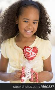 Young girl on Valentine&acute;s Day holding love themed balloon smiling