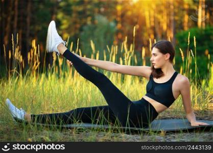 Young girl performs sports exercise in the forest. Young girl performs sports exercise in forest
