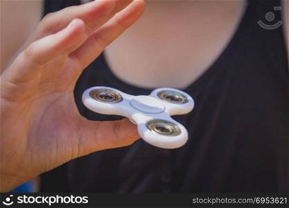 Young girl play with fidget spinner