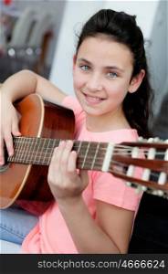 Young girl playing a guitar on the sofa at home