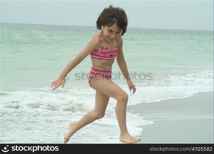 young girl playing at waters edge while on vacation