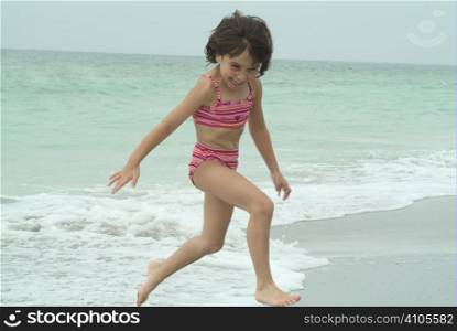 young girl playing at waters edge while on vacation