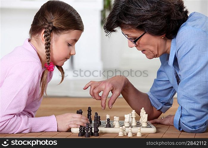 Young girl playing chess with grandma