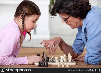 Young girl playing chess with grandma