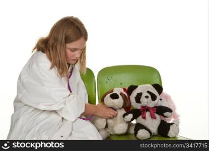 young girl playing doctor with her soft toys