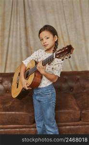 young girl playing guitar home 2