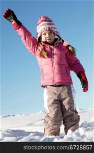 Young Girl Playing In Snow On Holiday In Mountains