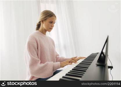 young girl playing keyboard instrument home