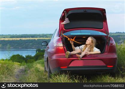young girl portrait at the car trunk. girl traveling by car. Fun summer