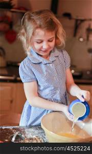 Young girl pouring water into a mixing bowl