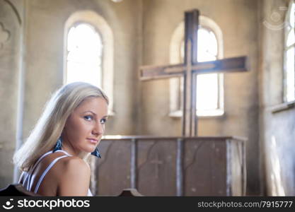 young girl praying in the church about the cross
